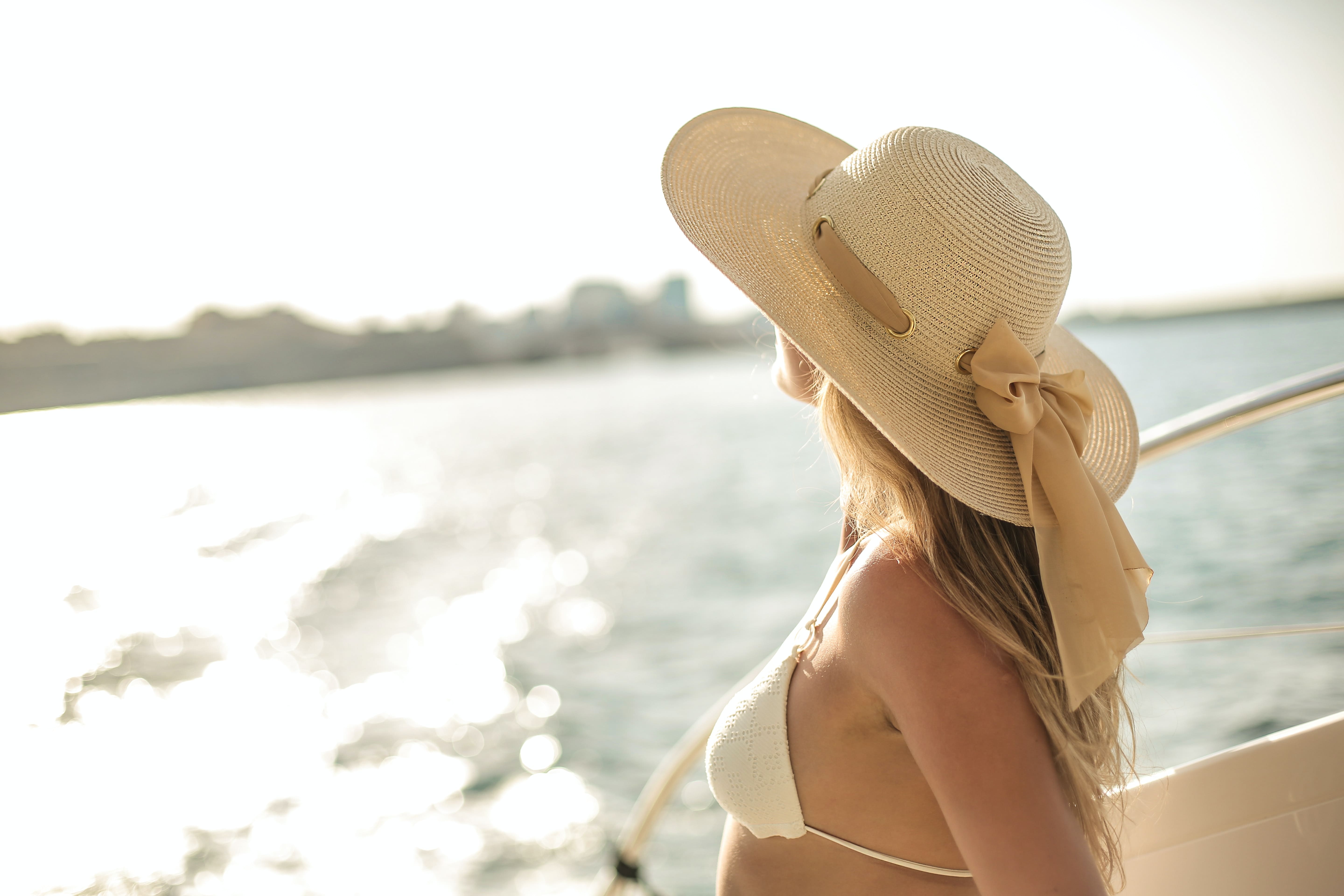 Yacht rentals in Tulum; women with a hat on a yacht
